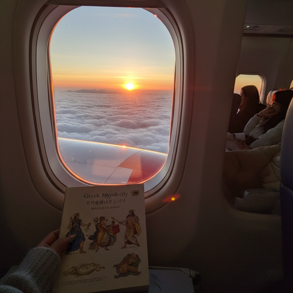 비행기 창문으로 보이는 구름 위 일출 장면